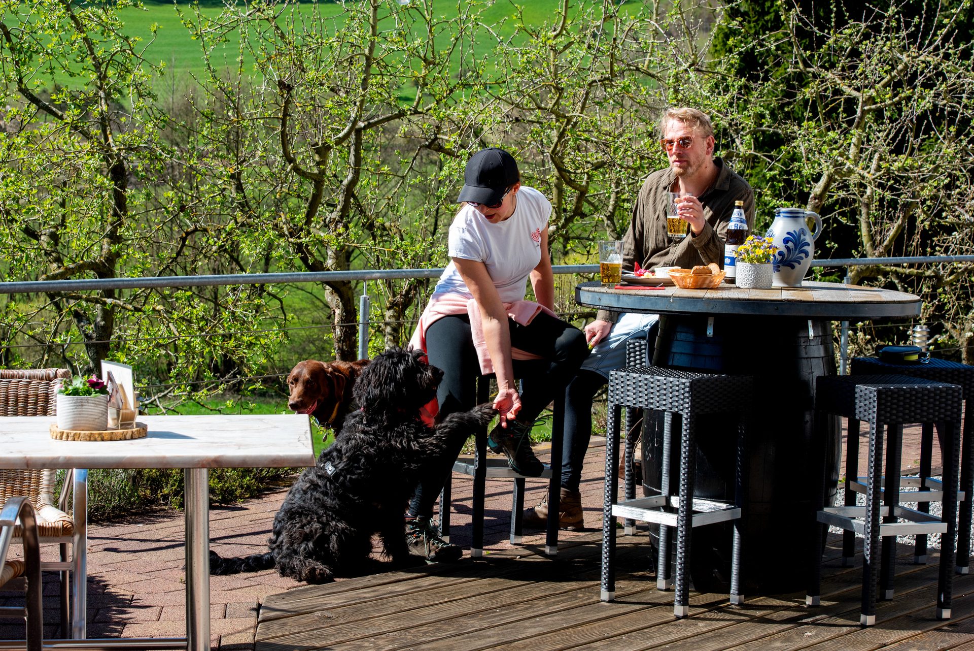 Paar mit Hund auf der Wirtshaus-Terrasse